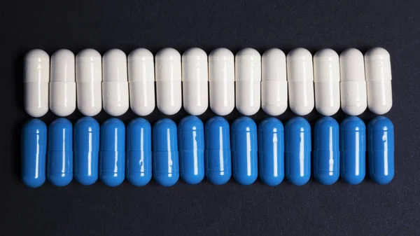 暗い背景に白と青の錠剤のライン — ストック写真