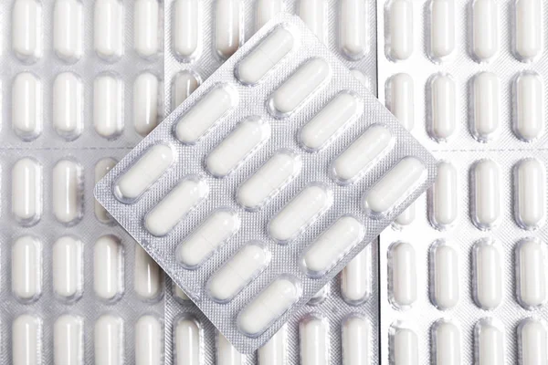 Tabletlerin Arka Planında Beyaz Kapsüller — Stok fotoğraf