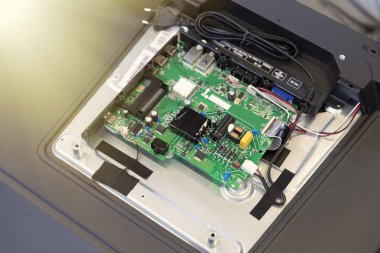 Montaj hattında arka kapağı açık bir televizyon. Ayarlanmış