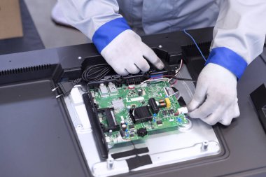 Fabrikadaki TV montajcısının yakın çekimi.