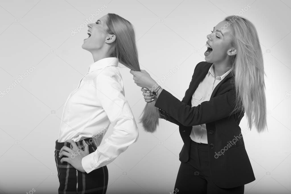 The girl pulls the hair of his colleague. Fighting in the workplace. Black and white photo
