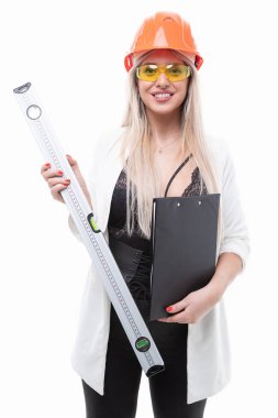 Turuncu miğferli, gözlüklü ve inşaat seviyesinde poz veren seksi sarışın.