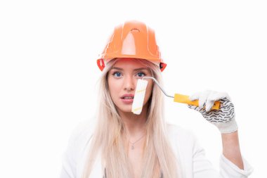 Sarışın, duvarları boyamak için bir inşaat tekeriyle makyaj yapıyor. Makyaj sanatçılarının beceriksizliği kavramı