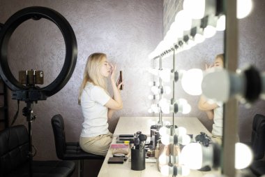 Kız bir güzellik atölyesinde makyaj konusunda yüksek lisans yapıyor.