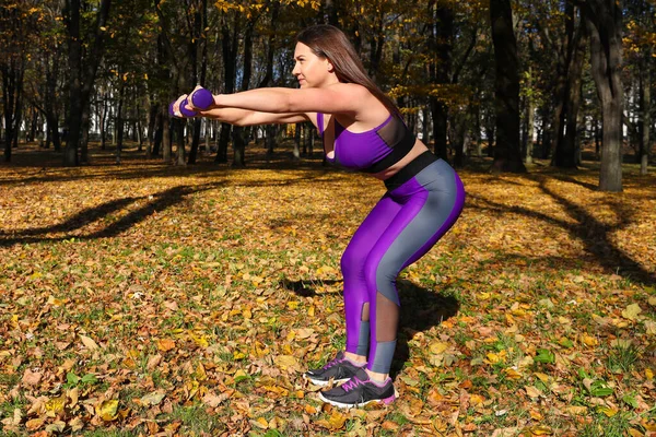 Parlak Eşofmanlı Bir Kız Parkta Dambıllarla Egzersiz Yapıyor — Stok fotoğraf