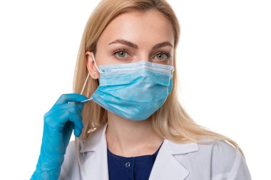 Beyaz arka planda koruyucu maskeli ve eldivenli bir doktorun portresi. Virüsün yayılmasını önleme kavramı