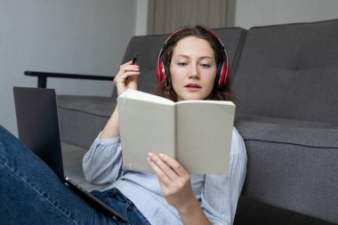 Kız, odada yerde oturuyor ve bilgisayarın başında çalışıyor. Evden planlama işi