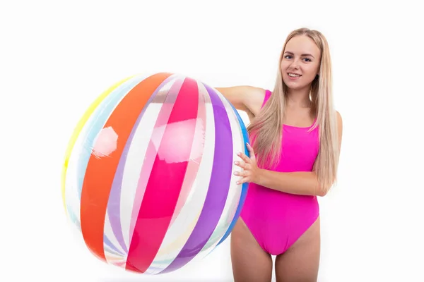 一个穿着粉色泳衣的漂亮姑娘拿着一个彩色充气球 — 图库照片