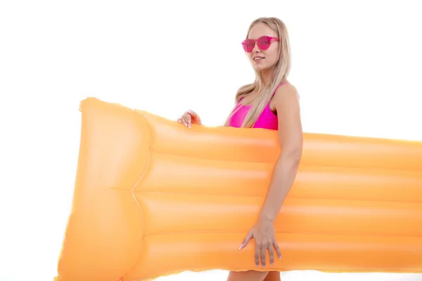 一个穿着粉色泳衣和眼镜的漂亮金发姑娘拿着一个气垫 — 图库照片