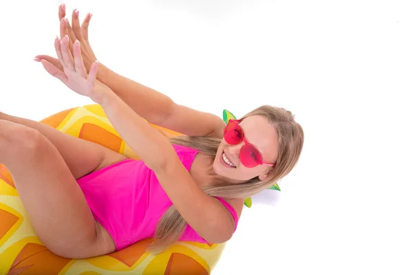 一个穿着粉色泳衣的微笑的女孩躺在一个充气的泳圈上 — 图库照片