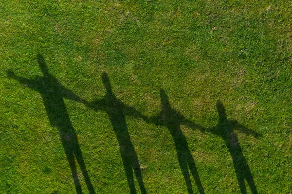 Najlepsze Ujęcie Cienia Czterech Ludzi Zielonej Trawie — Zdjęcie stockowe