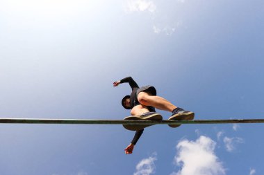 Bir adam metal bir korkulukta gökyüzüne doğru yürür.