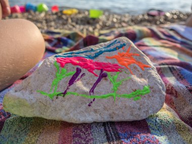 Çocuklar oynarken ve taşlar kumlu Plajı'nda denize tatile boyama.