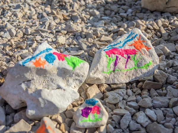 Çocuklar oynarken ve taşlar kumlu Plajı'nda denize tatile boyama.