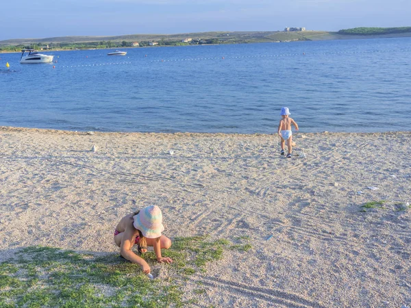 Güzel kumlu plaj akşam günbatımında oynayan çocuklar.