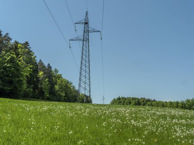 Yüksek gerilim enerji elektrik hatları yüksek ayağı çayırlar üzerinde gidiş ile.