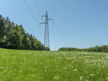 Yüksek gerilim enerji elektrik hatları yüksek ayağı çayırlar üzerinde gidiş ile.
