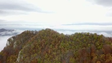 Hava: sonbahar renk ağaçlar ve sis vadilerde taşlı hills doğru uçan. Sabah uçuş yolu tepenin üstüne tahta haç ile.