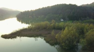 Hava: güzel gölet üzerinde akşam günbatımında sonbaharda uçan. Sakin güneşli hava temiz su yansıtan doğa ile yuvarlak göl.