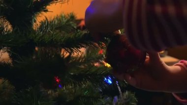 Küçük kız ile renk ışık ve parlak Ampüller Noel ağacı süsleme. Aile zaman filme ağır çekimde hd.