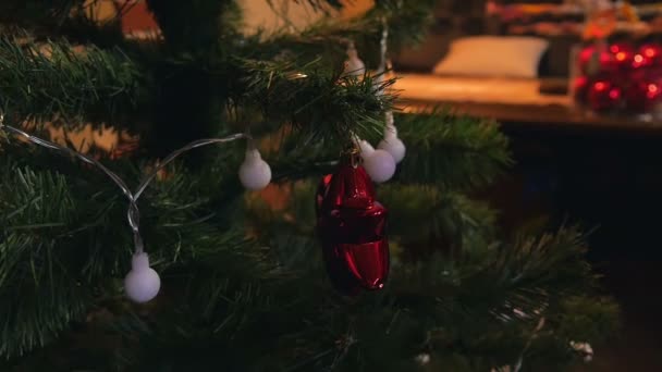 少女は 光沢のある電球色のライトとクリスマス ツリーを飾るします 家族との時間がスローモーションで撮影された — ストック動画