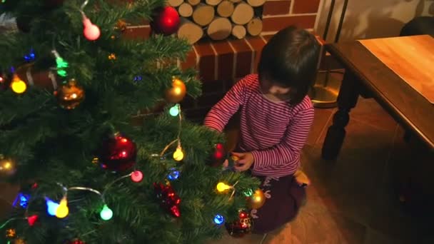 Liten Tjej Dekorera Julgran Med Färg Ljus Och Glänsande Lökar — Stockvideo