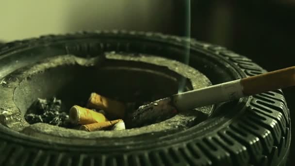 香烟放在烟灰缸边缘慢动作吸烟 离开香烟在橡胶轮胎仿制烟灰缸 — 图库视频影像