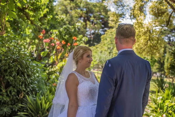 Sadece evli çift düğün giyen güzel yeşil bahçesinde poz Giydir. Avustralya inanılmaz kum plaj düğün ateş.