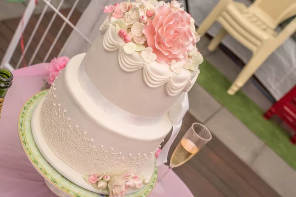 Gül şeklinde güzel süslemeli beyaz düğün pastası. Avustralya inanılmaz kum plaj düğün ateş.