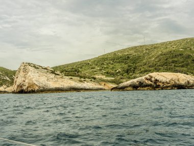 Rocks over Blue cave entrance at island Vis in Croatia. Shot from sailing boat. clipart