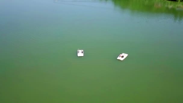在阳光明媚的日子里 飞越绿湖 上面有两艘脚踏船 在阳光明媚的夏日 用无人机飞行和拍摄 — 图库视频影像