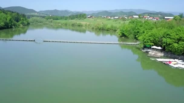 Aéreo Voando Sobre Pequeno Lago Com Ponte Flutuante Cruzando Sobre — Vídeo de Stock