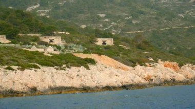 Hırvatistan adada beton eski askeri binalar. Ağır çekimde Adriyatik Denizi'nde ipucu yelken üzerinde filme hd.