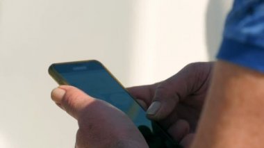 Siyah cep telefonu onun elinde tutan adam. Serching internet sayfaları aracılığıyla. Closeup telefon içinde yavaş hareket hd.
