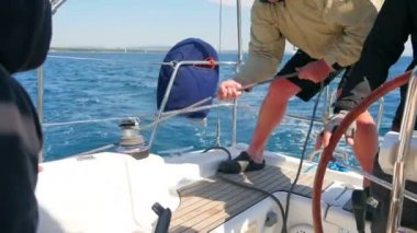 Erkek el Blacke ip çekerek yuvarlak yan vinç bir dönüş yaparken nefes nefese. Ağır çekimde Hırvatistan yelken gezisi olarak film hd.
