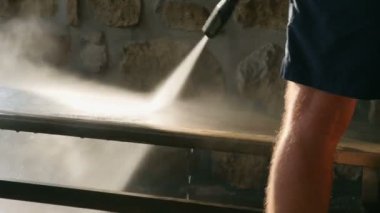 Ahşap Bank ile yüksek basınç su modeller slowmotion olarak temizlik. Mercek parlaması yapım gökkuşağı renkli güzel gün batımı püskürtme su.