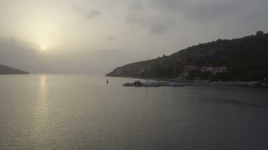 Hava: günbatımı doğru beton İskelesi ve Yelkenli tekneler denize sıfır üzerinde uçan. Hırvatistan Adriyatik denizinde yelken gezisi olarak film.