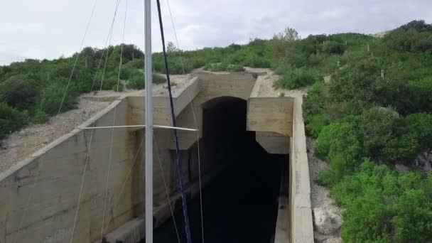 空中飞行 在隐藏机库的混凝土海军废弃潜艇前飞行 帆船工作人员用它安全地把他们的帆船停在里面 — 图库视频影像