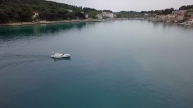 Hava: eve küçük balıkçı teknesi önünde taş iskele üzerinde açılış dron. Hırvatistan Adriyatik denizinde yelken gezisi olarak film.