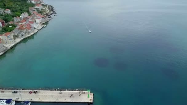 緑色の信号光と石の桟橋の前に下がって空中 ドローン クロアチアのアドリア海の航海の旅で撮影 — ストック動画