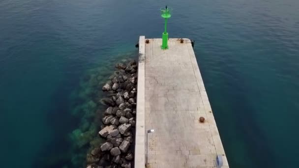 在混凝土码头上空飞行 最后有绿色的钢光信号柱 码头被美丽的蓝色地中海海水包围 — 图库视频影像