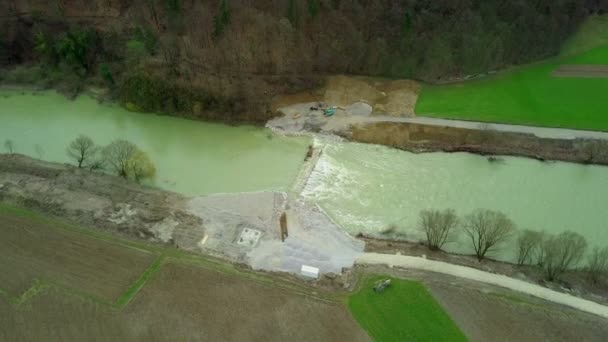 Aérien : Voler devant le chantier de construction du pont avec la rivière débordant. La fonte des neiges a fait monter et couler la rivière sur le chantier de construction du pont .