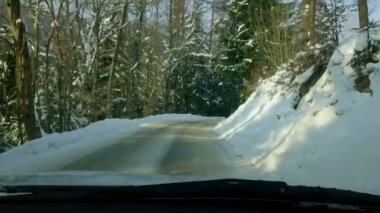 Orman donmuş yolda soğuk soğuk kış sabahı sürüş. Karla kaplı yol tepeye eğrisi yoluyla oluyor.