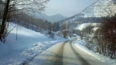 Karlı kırsal soğuk kış sabahı güneş doğuyor sürüş. Güzel beyaz yatay, arka planda büyük taş ocağı.