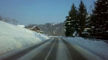 Karlı kırsal soğuk kış sabahı güneş doğuyor sürüş. Yol kenarında, yeşil çam ağaçları.