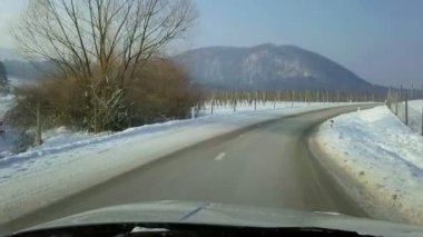 Çiftlik topraklarda kar ile kaplı araç önden görünüm içinde filme. Yol elma meyve bahçeleri ile gidiyor.