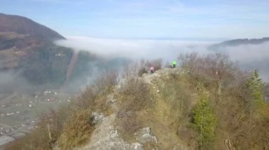 Hava: tepenin zirvesine civarı güzel güneşli kış gününde uçan. Tepenin üstündeki birkaç tanınmaz yürüyüşçü.