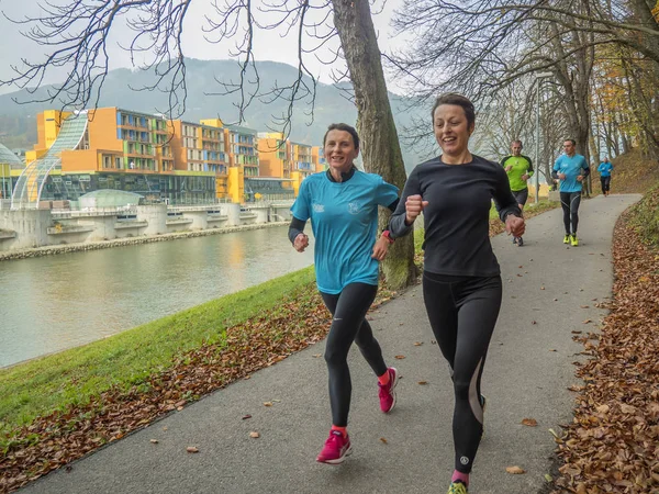Lasko, Slovenya, 11.11.2017, sadaka çalıştırmak: nehrin yanında çalışan katılımcıların.