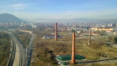 Hava: eski terk edilmiş fabrikası kırmızı tuğla üzerinde uçan uçak baca inşa. Arka planda ile şehir ve mavi gökyüzü.