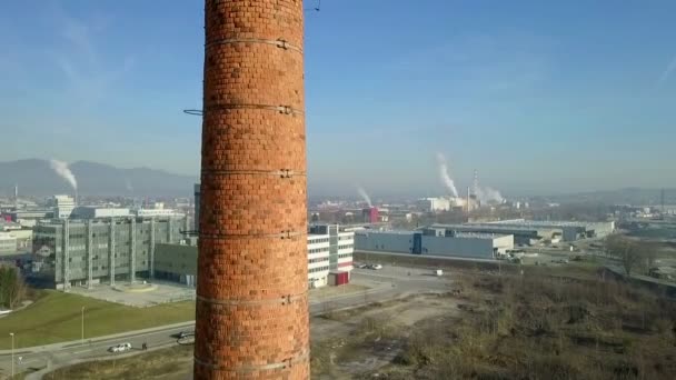 无人机升降在老废弃红土砖建厂烟囱附近 背景中的工业区 很少有鸽子在烟囱顶上放松 — 图库视频影像